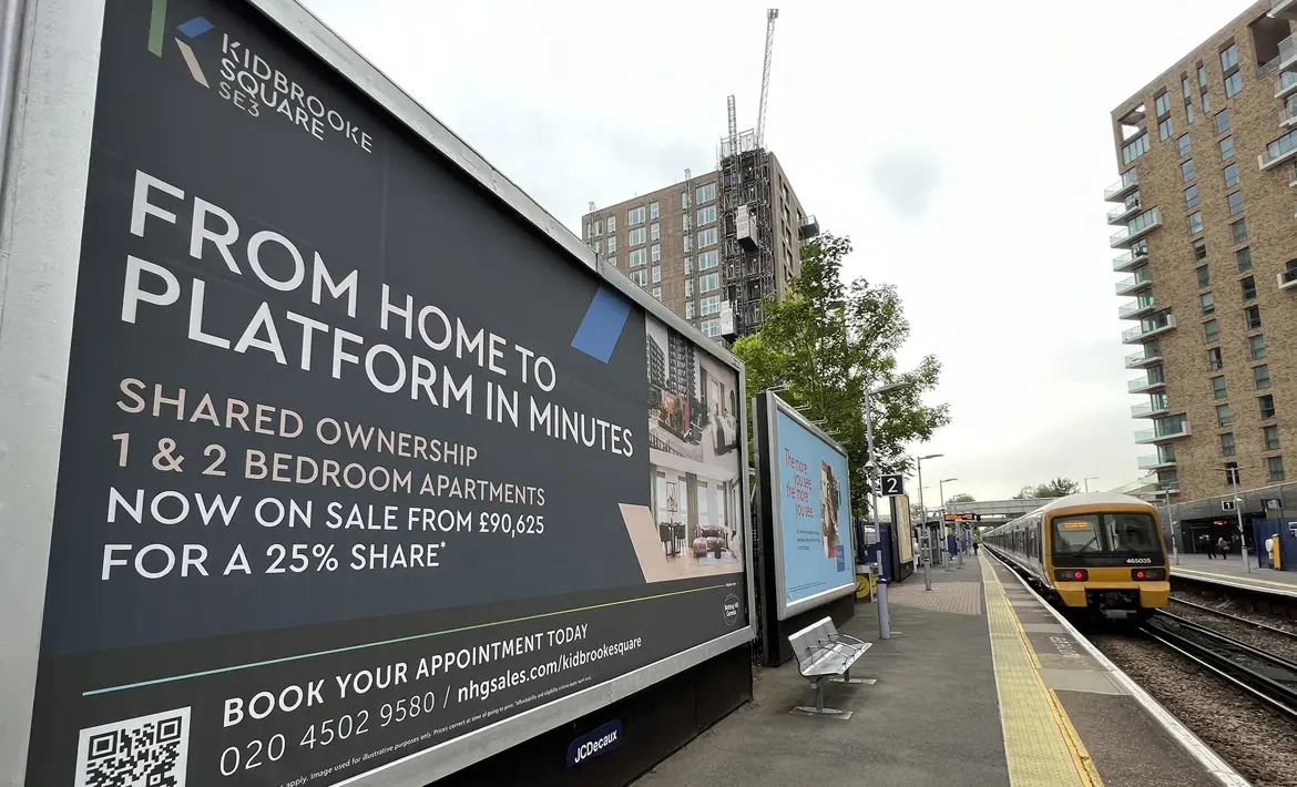 Looking along Kidbrooke Train Station with a Southeastern train arrived at the platform. Kidbrooke Square signage on show.