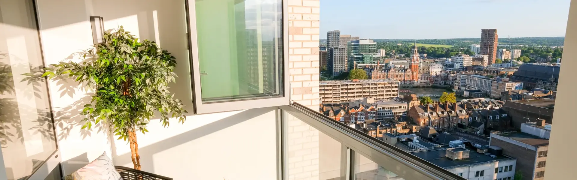 Winter garden with floor-to-ceiling windows, decorative planting, seating area and city views.