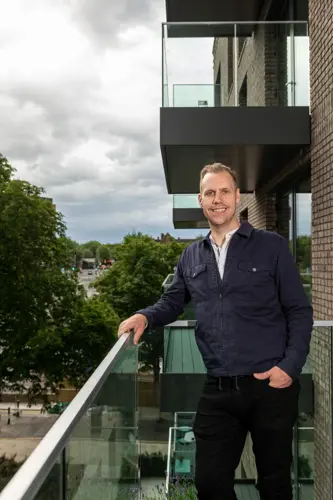 Ryan stands on his balcony at Heron Quarter