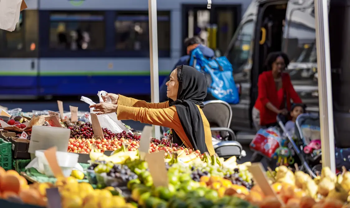 A lady buying fresh produce and fruits at the local store.